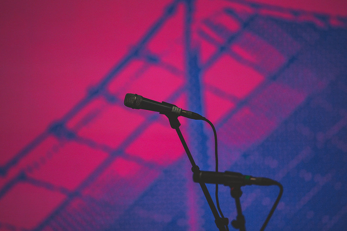 Microphones against pink and blue stage backdrop credit Jacinta Keefe