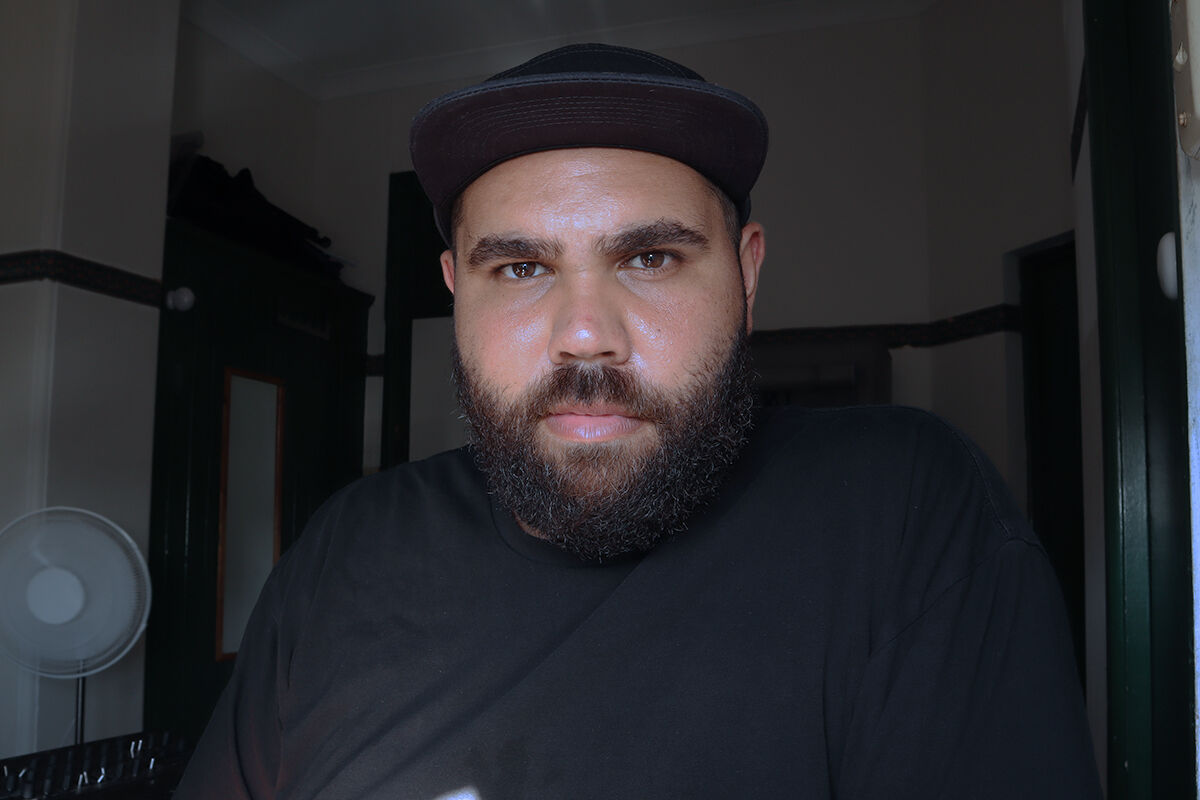 Blake Rhodes - male with beard, in black hat, black shirt looking direct to camera.