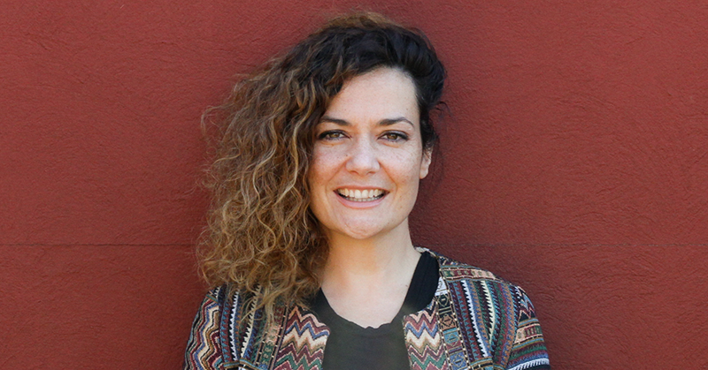 Leah Flanagan stands in front of a red wall