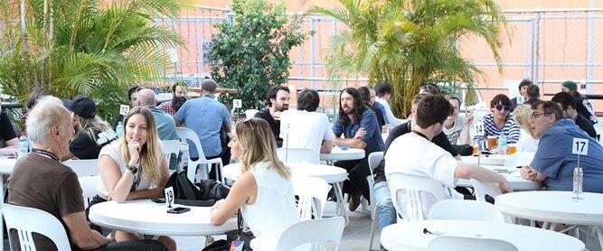 Groups of people networking at outdoor tables