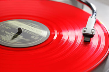 A red vinyl record playing on a record player