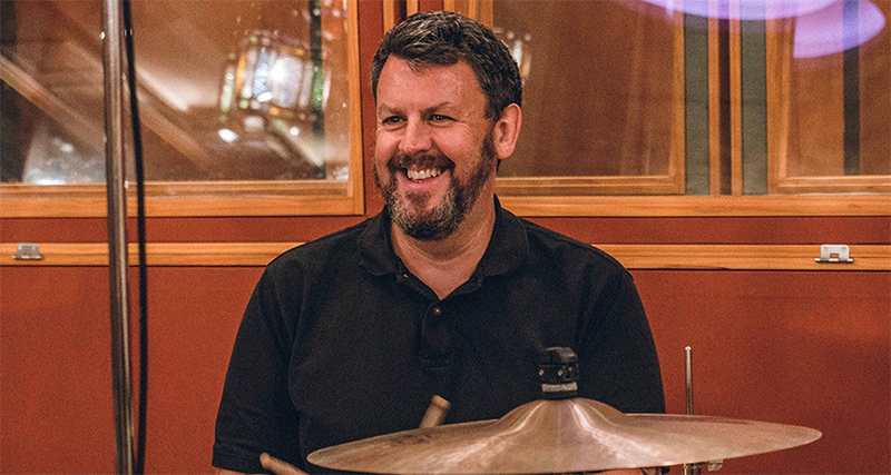 Music producer Greg Haver sits by a drum kit